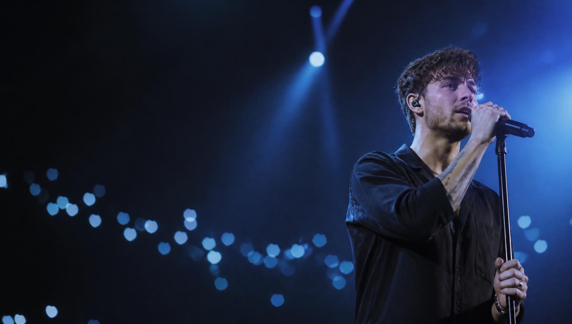 Cantor no palco sob luzes de show